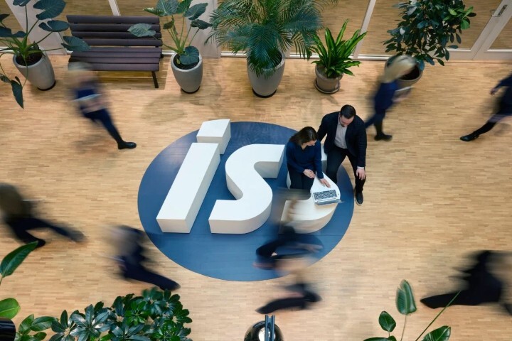 People moving around in an office with large ISS logo